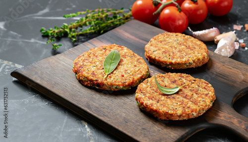 Vegetables patties or cutlets for vegan burgers on wooden cutting table, black marble background.