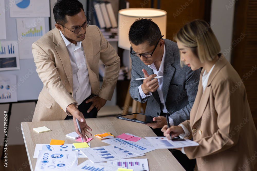 Fototapeta premium Group of confident business people point to graphs and charts to analyze market data, balance sheet, account, net profit to plan new sales strategies to increase production capacity. 