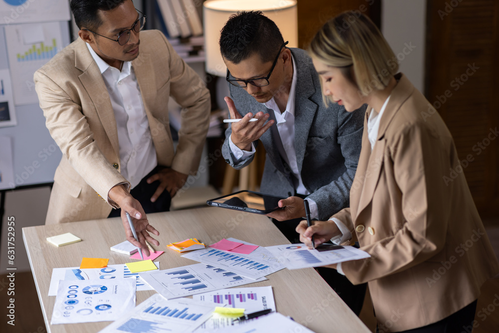 Group of confident business people point to graphs and charts to analyze market data, balance sheet, account, net profit to plan new sales strategies to increase production capacity. Group of confident business people point to graphs and charts to analyze market data, balance sheet, account, net profit to plan new sales strategies to increase production capacity.