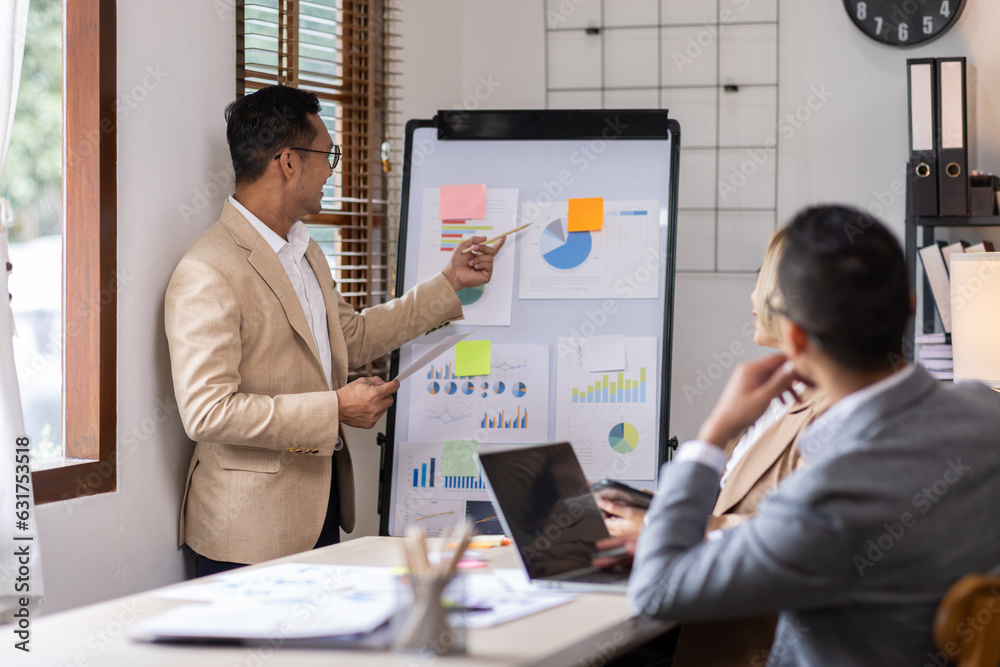 Group of confident business people point to graphs and charts to analyze market data, balance sheet, account, net profit to plan new sales strategies to increase production capacity. Group of confident business people point to graphs and charts to analyze market data, balance sheet, account, net profit to plan new sales strategies to increase production capacity.
