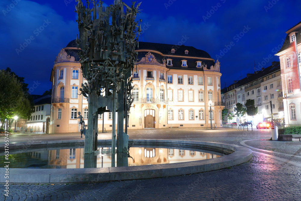 Fastnachtsbrunnen und historisches Hotelgebäude in Mainz bei Nacht