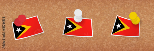 East Timor flag pinned in cork board, three versions of East Timor flag.