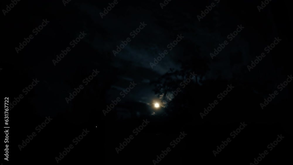 time lapse of august super full moon is rising between passing clouds, horror scene, black background