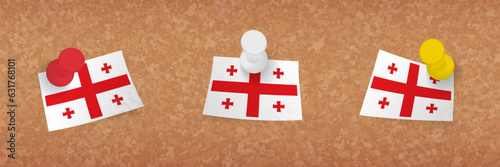 Georgia flag pinned in cork board, three versions of Georgia flag.