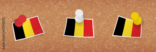 Belgium flag pinned in cork board, three versions of Belgium flag.