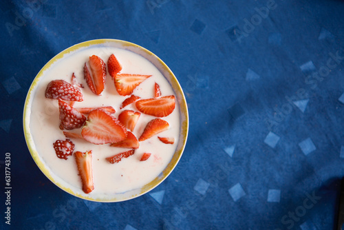 Strawberries in a plate with milk top view