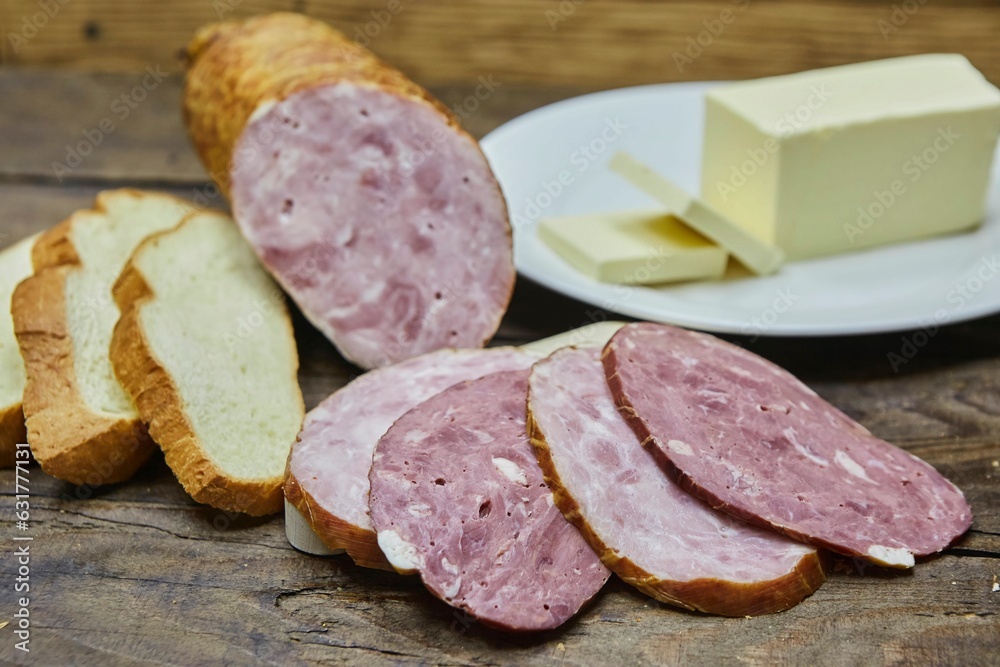 Smoked or dried sausage surrounded by bread and butter. Breakfast products. Meat production Smoked or dried sausage surrounded by bread and butter. Breakfast products. Meat production