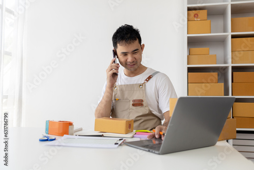 Person is talking on the phone with a customer, selling products online, packing orders from customers who place orders through online shopping sites. Concept of selling products online and e-commerce