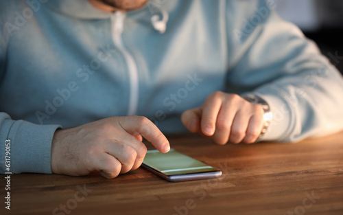 Close-up of male hands surfing internet on modern smartphone. Businessman searching information via special cellphone app. Social networks and modern technology concept