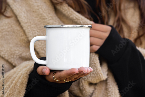 Girl is holding enamel camping mug in hands. Blank enamel white cup. Blank mug printing design template, camping mug mock up. 