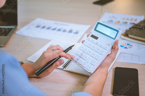 Business asian woman sitting at a desk at an office By using the calculator to work. Business Concept Analysis and Planning.