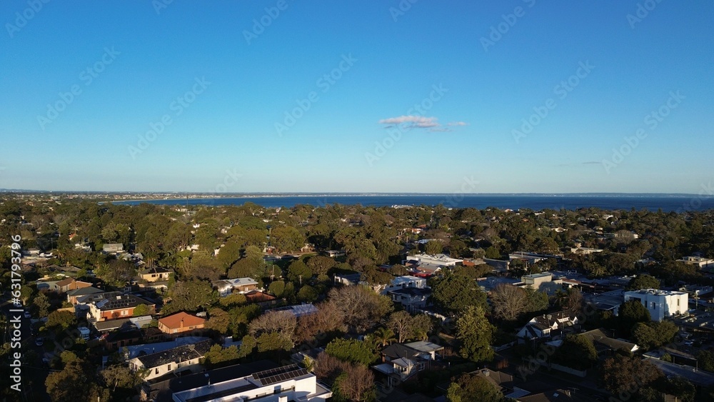 Beautiful aerial view of urban area with ocean visible further away with a cloud in the sky Beautiful aerial view of urban area with ocean visible further away with a cloud in the sky