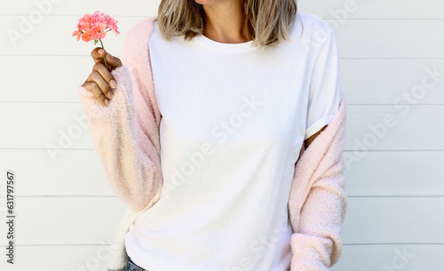 Woman wearing blank white tshirt with copy space for your text or design with pink sweater and flower 