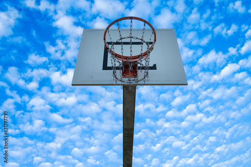 High basketball hoop with blue sky and clouds scenery