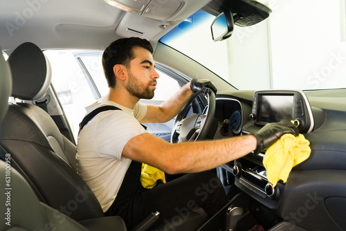 Car wash service worker cleaning vehicle interior