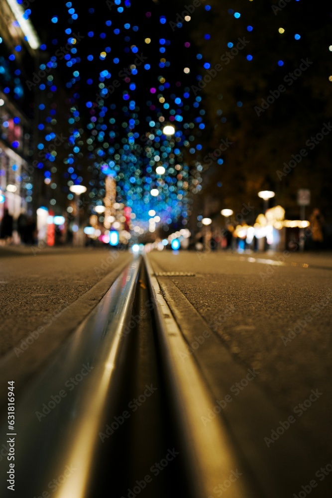 Low-angle view of a city street lined with blue lights overhead