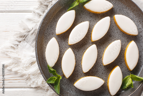 Calissons are a Provencal candy composed of a light paste of crystallised melon, orange and almonds coated with royal icings closeup on the table. Horizontal top view from above photo