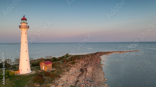 Stunning view of the Kihnu lighthouse against a backdrop of the sea at sunset photo
