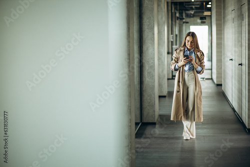 Business woman using phone and walkingh at the office