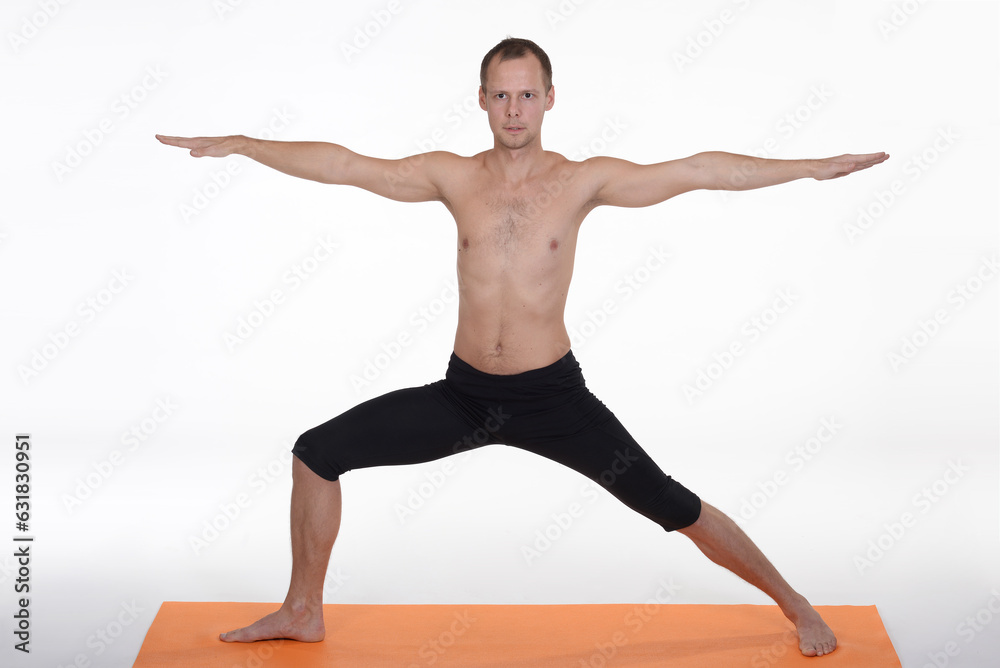 Man doing yoga in photo studio on isolated background.	