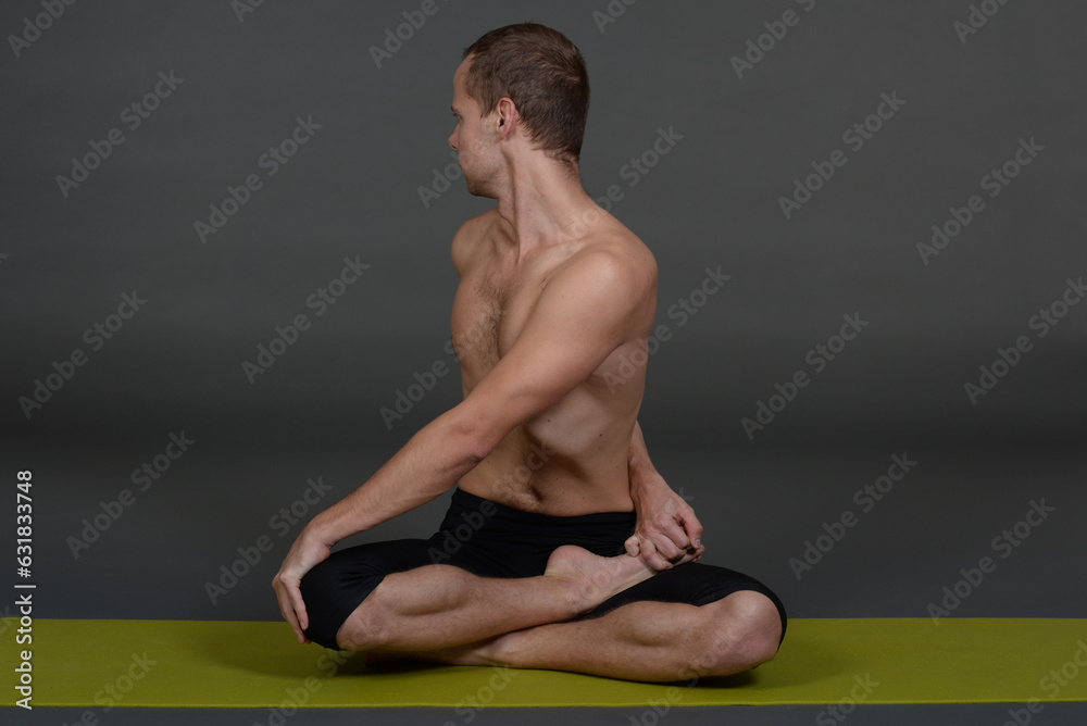 Man doing yoga in photo studio on isolated background.	