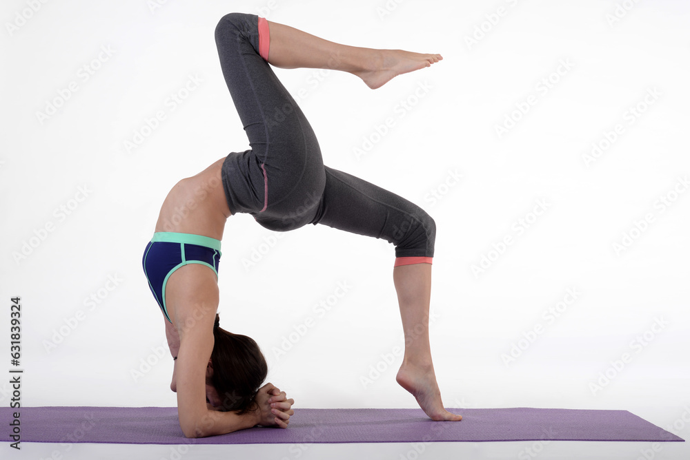 Woman doing yoga in photo studio on isolated white background.	

