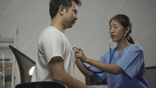 Wallpaper Mural Beautiful Asian doctor measuring blood pressure for young female patient in examination room. A stethoscope is placed on the crook to listen to the heartbeat. Torontodigital.ca