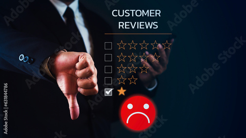 Businessman is using smartphone and showing thumb down for dissatisfied feedback review against dark blue background.