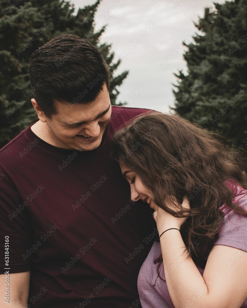 Vertical closeup shot of a young couple laughing and having fun together Vertical closeup shot of a young couple laughing and having fun together