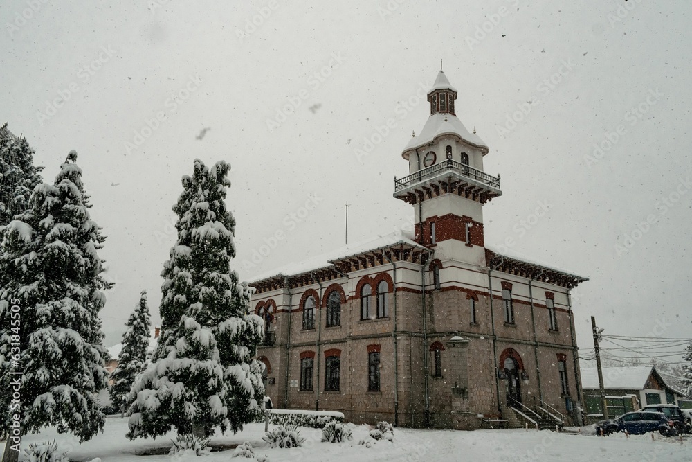 Obraz premium Beautiful shot of the historic Targu Ocna Town Hall covered in snow