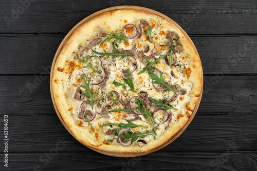 Pizza with veal, red onion and arugula on wooden background, top view, flat view picture for menu