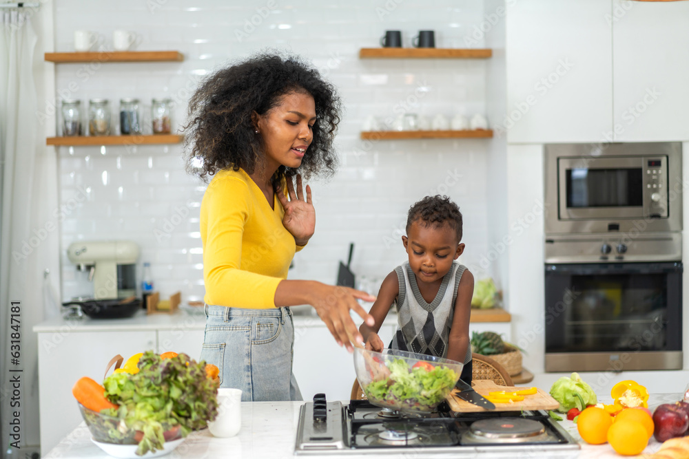 Portrait of enjoy happy love african american family mother and african little boy son child having fun help cooking food healthy eat together with fresh vegetable salad and ingredient in kitchen