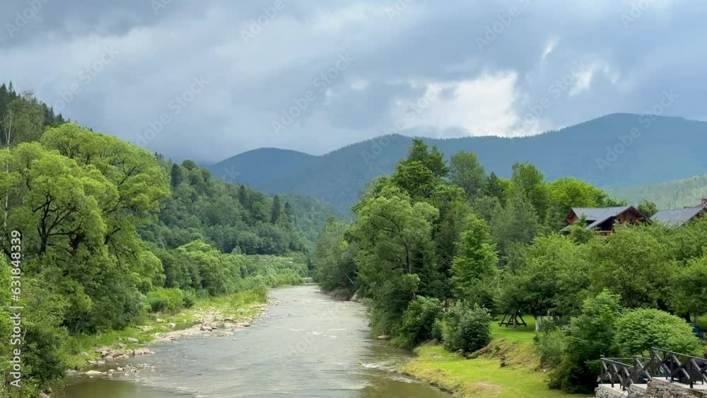 Beautiful view of a river flowing from the mountains. River surrounded by bunch of green trees. Cloudy day in Carpathian. Beautiful view of a river flowing from the mountains. River surrounded by bunch of green trees. Cloudy day in Carpathian.