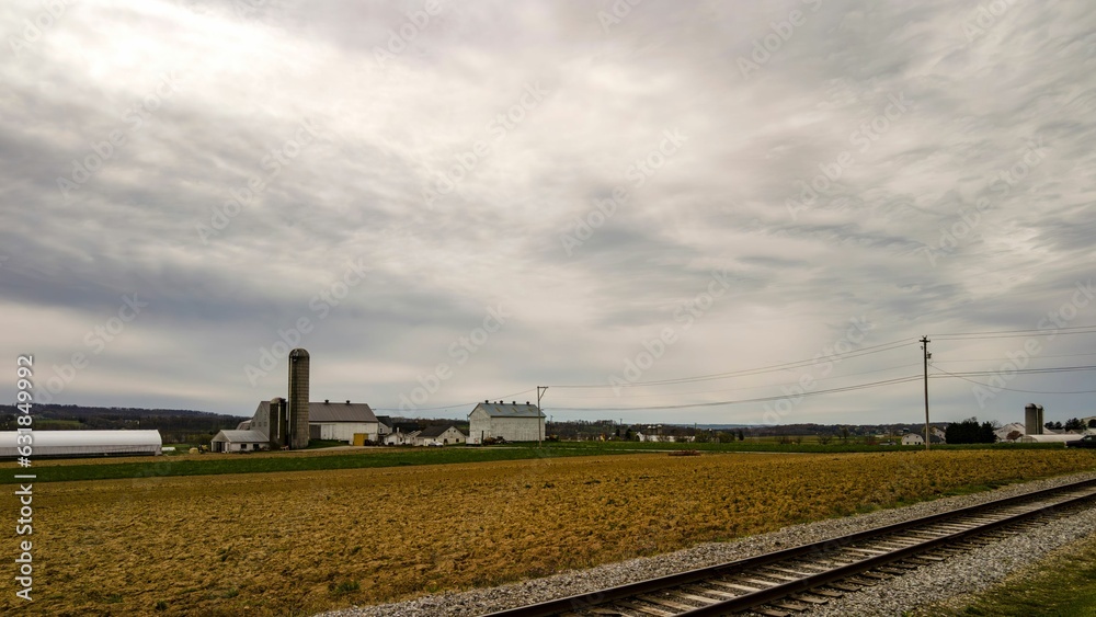 An Amish farm with barns and silo on a cloudy day. An Amish farm with barns and silo on a cloudy day.