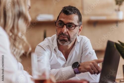 Tablou pe pânză Confused middle-aged company manager discussing issues at work with his middle-a