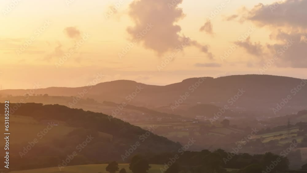Aerial of the beautiful green hills and mountains during the bright golden sunset Aerial of the beautiful green hills and mountains during the bright golden sunset