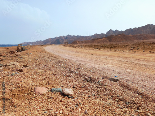 Panoramic view of unpaved road in the desert of the Sinai Peninsula. Sandy road on the Red Sea coast. Extreme landscapes and desert routes.