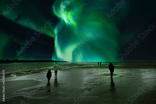 People standing on a beach, staring up in wonder at the colorful Aurora Borealis in the night sky