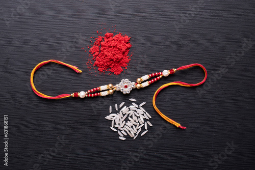 Top view of premium rakhi with roli chawal at textured background photo