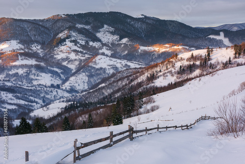 carpathian rural landscape i winter. wooden fence on the snow covered hill. bright sunny day