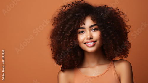 Gorgeous African American woman showcases flawless, radiant skin against a beige backdrop. A captivating smile graces Afro beauty with luscious, curly black hair.