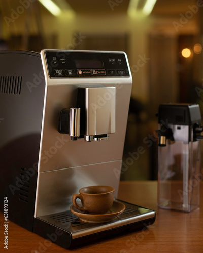 Modern espresso coffee machine with a cup in kitchen.