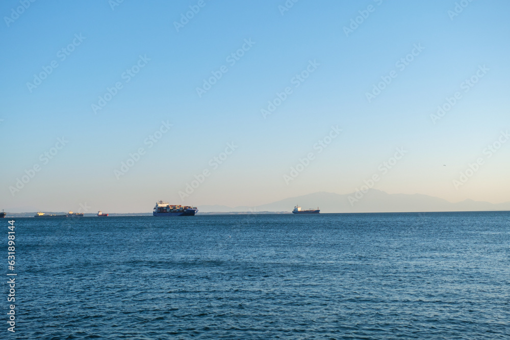 two container ships in the bay of thessaloniki by sunset
