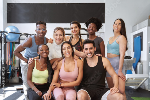 multicultural group of fitness people looking at camera and smiling at the gym