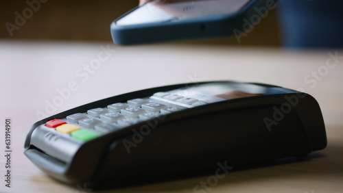 Hand using nfc technology on cellphone for purchase closeup. Terminal payment 