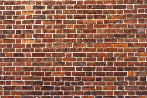 Old brick wall made of dark red bricks. Texture of a brick wall