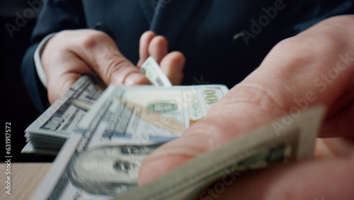 Hands collecting dollars piles at desk closeup. Business man counting banknotes.