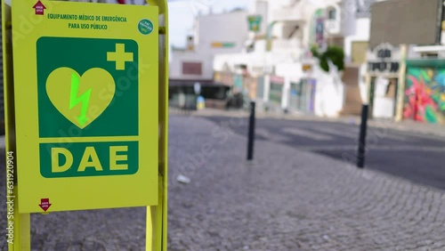 An heart defibrillator machine on the public street showing the unit on the street with cars passing by on the road located in Albufeira in Portugal photo