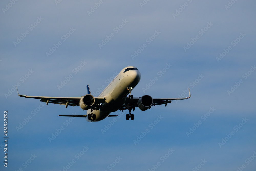 A commercial airplane approaching the airport during sunset.