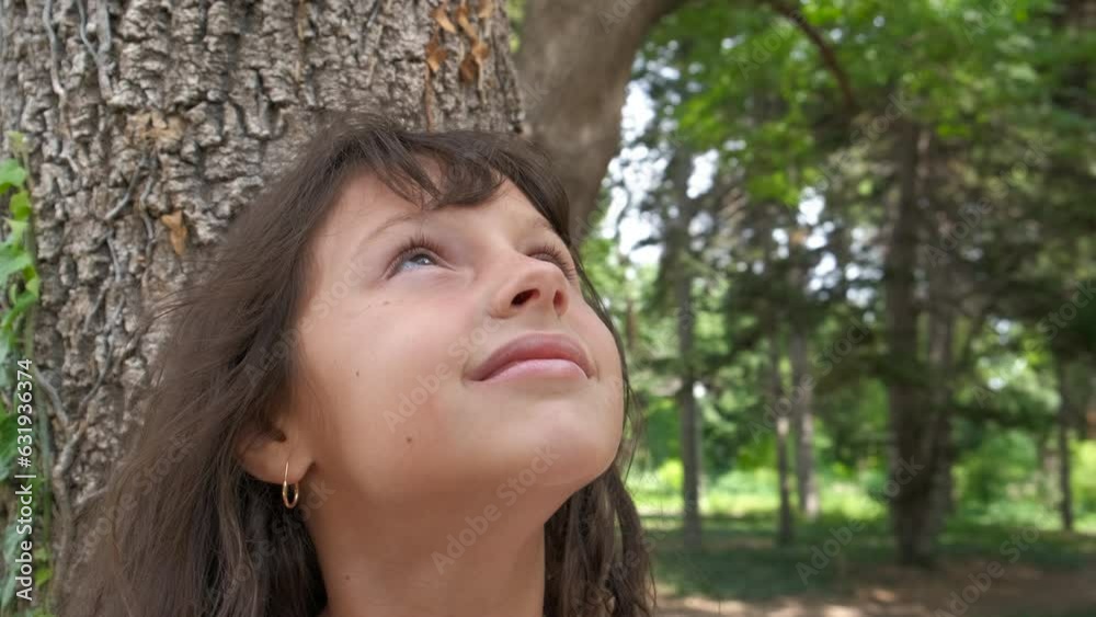 Nature lover child in eco forest. A little girl admire the green nature in the sunny forest. A concept of feel the love for nature and green planet. Nature lover child in eco forest. A little girl admire the green nature in the sunny forest. A concept of feel the love for nature and green planet.